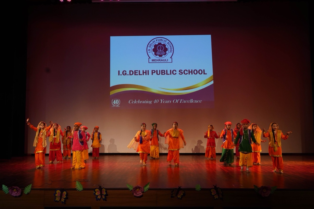 Students performing a group dance on stage at the Annual Day